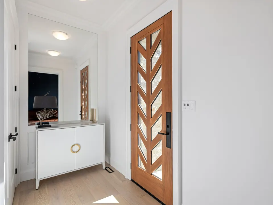 Entry hall with the Mastergrain chevron door seen from inside, a white console and the white oak floor