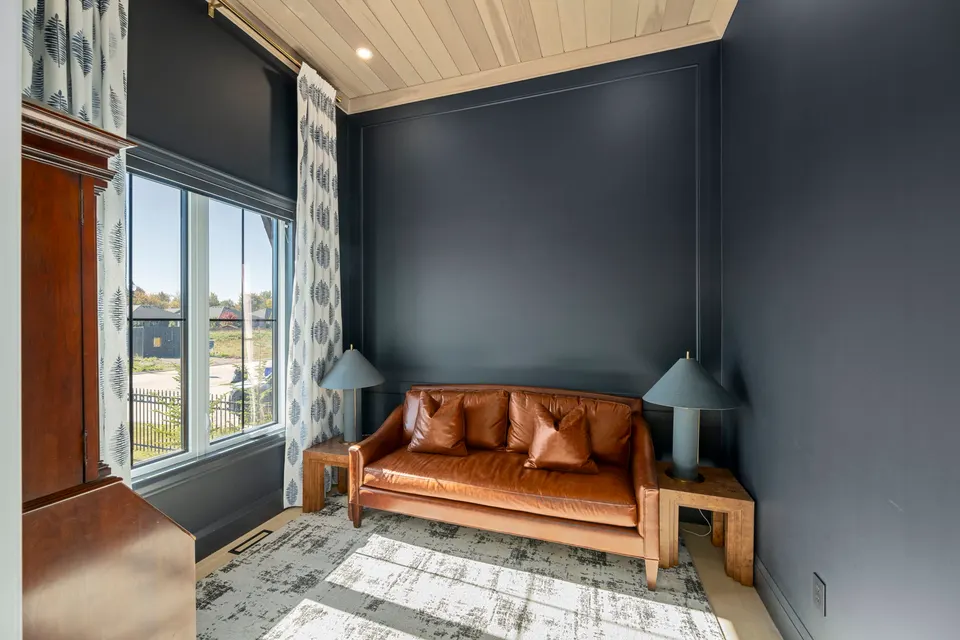 Den with navy walls and leather sofa