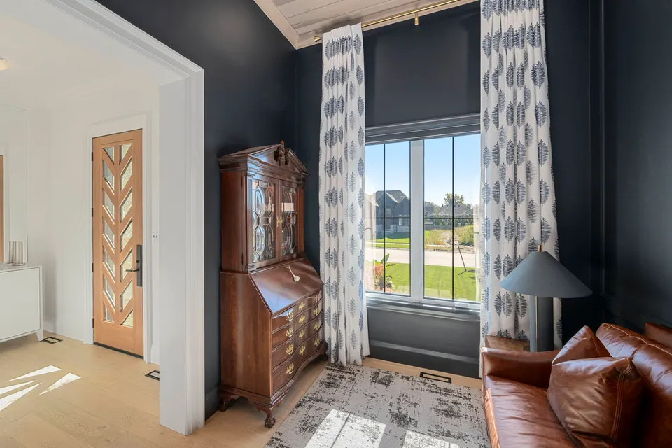 Den with Benjamin Moore Soot walls and a secretary desk, the chevron front door beyond