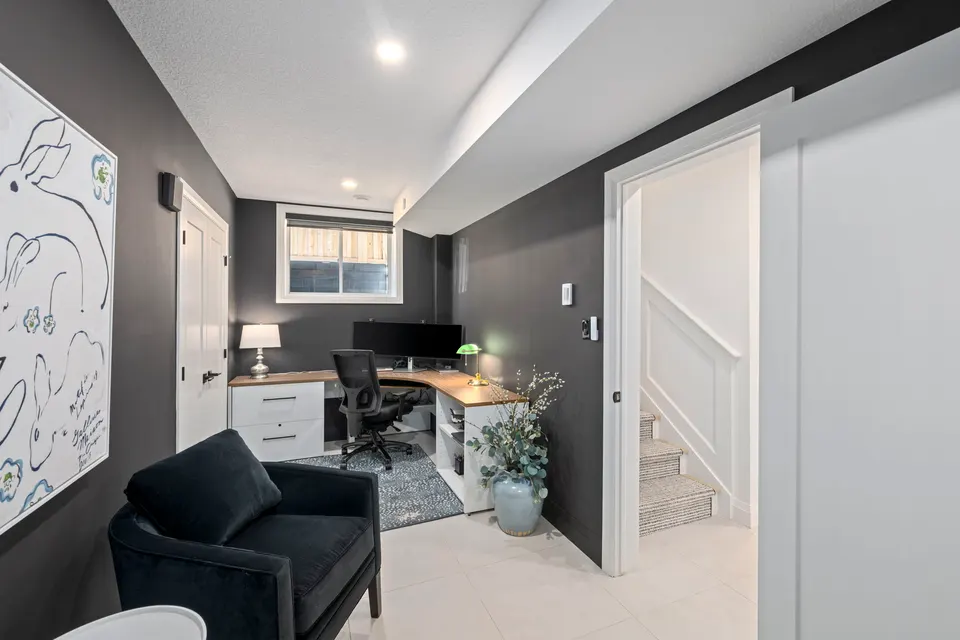 Lower level office with dark walls and a desk
