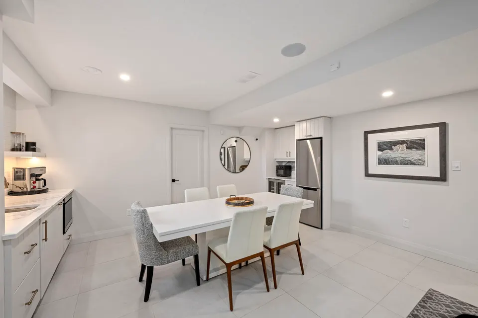 Lower level kitchen with dining table and full-size fridge