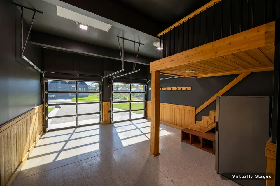 Garage looking out through the black glass doors, with the cedar storage loft overhead, virtually staged